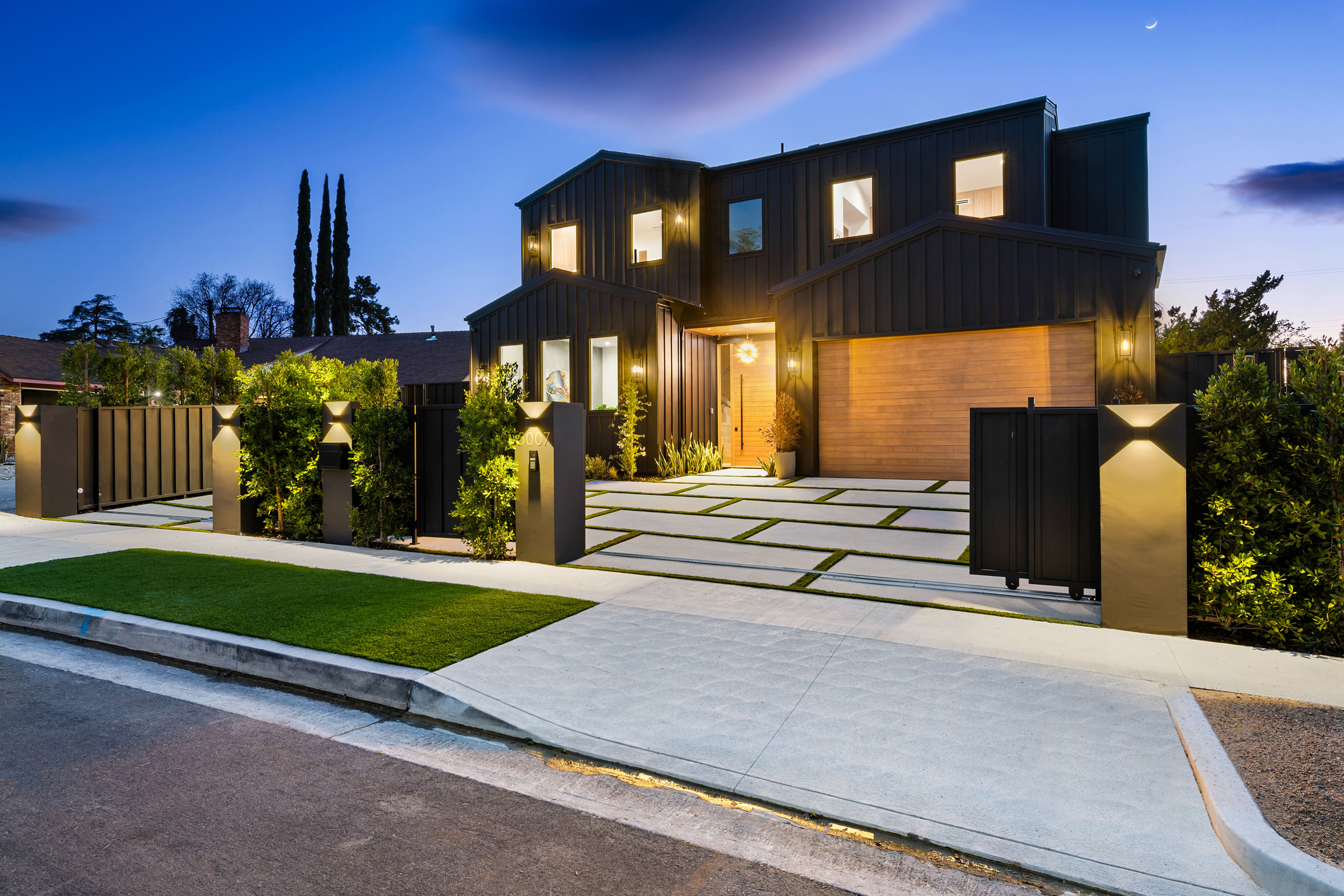 Modern custom home with illuminated exterior at dusk