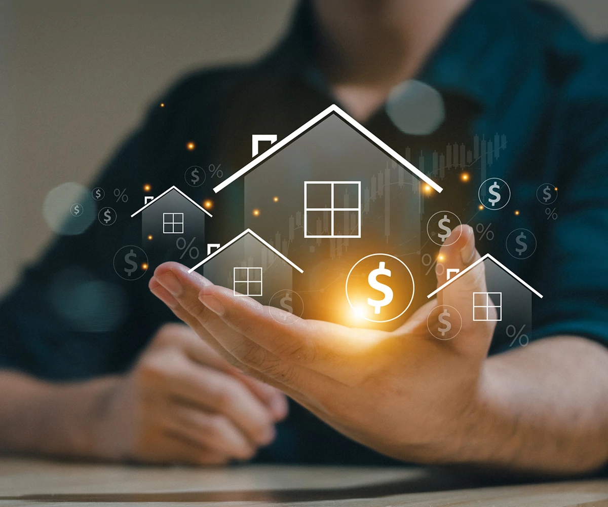 Hand holding digital house icons with dollar signs